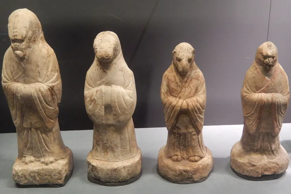 Quatre statuettes funéraires en pierre à tête d'animal du zodiaque chinois, vêtues de longues robes, les mains jointes